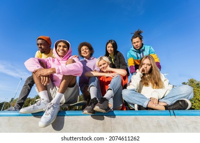 Multicultural group of young friends bonding outdoors and having fun - Stylish cool teens gathering at urban skate park - Shutterstock ID 2074611262