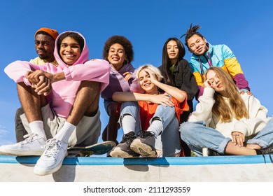Multicultural group of young friends bonding outdoors and having fun - Stylish cool teens gathering at urban skate park - Shutterstock ID 2111293559