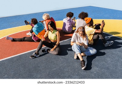 Multicultural group of young friends bonding outdoors and having fun - Stylish cool teens gathering at urban skate park and using mobile phone apps online and social media - Powered by Shutterstock