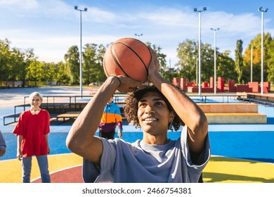 Multicultural group of young friends bonding outdoors and having fun - Stylish cool teens gathering at urban skate park  playing basketball - Powered by Shutterstock