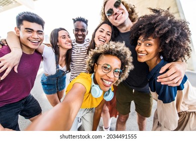 Multicultural Happy Friends Having Fun Taking Group Selfie Portrait On City Street - Multiracial Young People Celebrating Laughing Together Outdoors - Happy Lifestyle Concept	