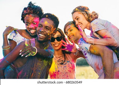 Multicultural Happy Friends Piggybacking Together At Holi Festival