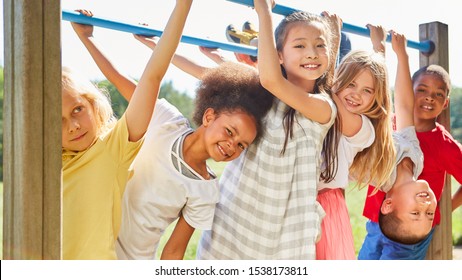 Multicultural kids as friends while doing gymnastics on a jungle gym - Shutterstock ID 1538173811