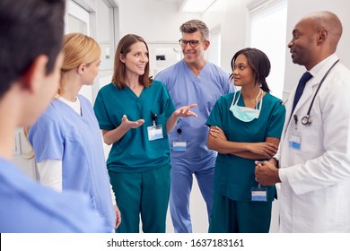 Multi-Cultural Medical Team Having Meeting In Hospital Corridor