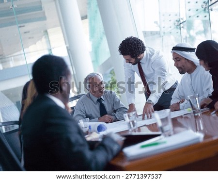 Multicultural Middle Eastern corporate team collaborating in a modern office business meeting around a conference table