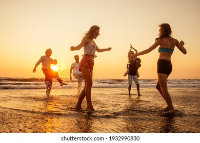 multicultural multinational happy people running into the sun carefree and happiness, vacation on sea - Shutterstock ID 1932990830