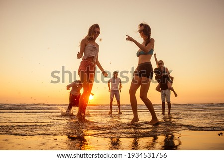 multicultural multinational happy people running into the sun carefree and happiness, vacation on sea