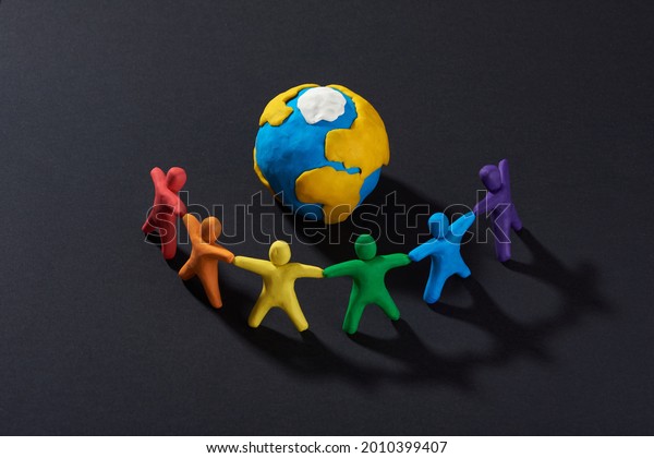 Multicultural people\
around Earth. Justice and no racism concept. Gender and racial\
equality. DIY. Children\'s crafts from colored plasticine. Group of\
people around the\
world.