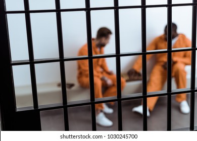 multicultural prisoners playing chess behind prison bars - Powered by Shutterstock