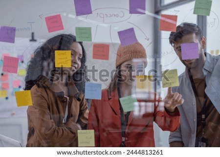 Multicultural startup team brainstorm, exchange ideas, develop fresh perspective by using sticky notes. Working collaboratively as a team help generate innovative idea, potential solution for company