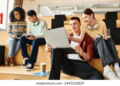Multicultural students sit on steps, absorbed in laptops for educational purposes.