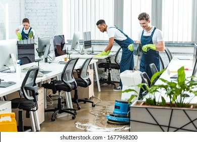multicultural team of cleaners working in modern open space office