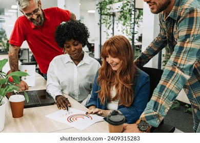 A multicultural team is working on database research while analyzing chart at modern office. A cheerful diverse team is having briefing and doing statistics while looking at the chart at the workspace