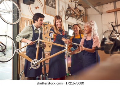 Multi-Cultural Team In Workshop Assembling Hand Built Sustainable Bamboo Bicycle Frame - Powered by Shutterstock