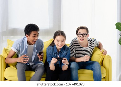 Multicultural Teen Boys Supporting Friend Playing Video Game At Home