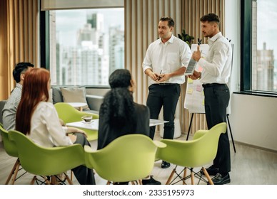 In multicultural workspace, innovative project manager present sustainable solar panel product, fostering collaboration and diversity among colleagues, aiming for efficient, renewable energy solution - Shutterstock ID 2335195973