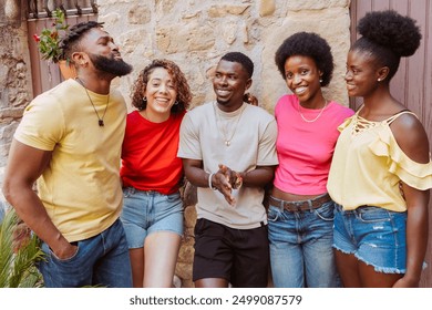 Multicultural young group of people enjoying together outdoors - Five friends having fun at street - Youth community concept with guys and girls interacting and conversating - Powered by Shutterstock