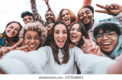 Multicultural young people smiling together at camera outside - Happy friends taking selfie pic with smart mobile phone device - College students having fun - Youth community concept - Powered by Shutterstock