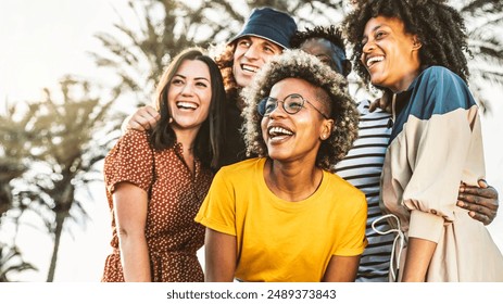 Multicultural young people smiling together outside - Happy group of friends having fun walking in city street - Youth community concept with guys and girls hanging out on a sunny day - Powered by Shutterstock