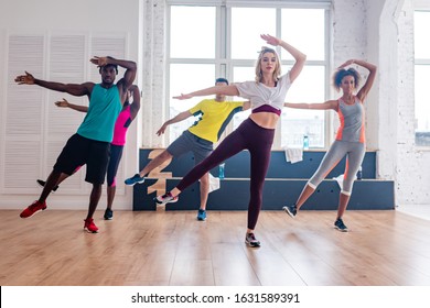 Multicultural zumba dancers practicing movements in dance studio - Powered by Shutterstock