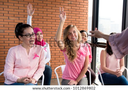 Multiethinic women wearing pink color clothes with ribbons meeting for breast cancer awareness campaign