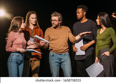 multiethnic actors and actresses rehearsing with theater director on stage - Powered by Shutterstock