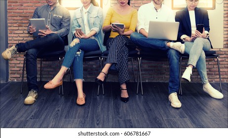 Multiethnic asian business group in casual suit using smart phone, tablet and laptop for working or playing social network and web site in modern office. Business and Technology concept