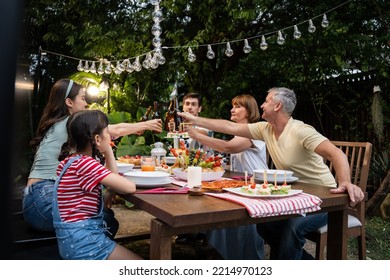 Multi-ethnic Big Family Having Fun, Enjoy Party Outdoors In The Garden. Attractive Diverse Group Of People Having Dinner, Eating Foods, Celebrate Weekend Reunion Gathered Together At The Dining Table.