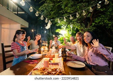 Multi-ethnic big family having fun, enjoy party outdoors in the garden. Attractive diverse group of people having dinner, eating foods, celebrate weekend reunion gathered together at the dining table. - Powered by Shutterstock