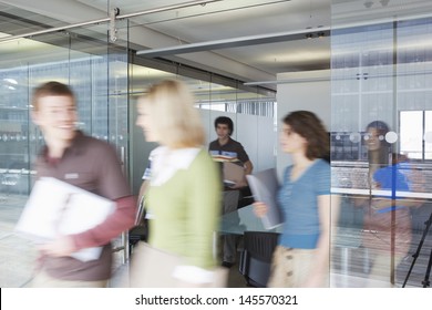 Multiethnic blurred office workers leaving conference room