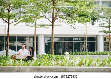 Multi-ethnic Business Colleague Having Meeting Outside The Offie Building And Discussing Project They Are Working On