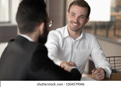 Multi-ethnic business partners before starting or accomplish negotiations shaking hands express respect, boss and applicant finish successful job interview hr first impression partnership sign concept