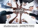 Multiethnic business people holding jigsaw pieces and merge them together as effective solution solving teamwork, shared vision and common goal combining diverse talent. Below view. Habiliment