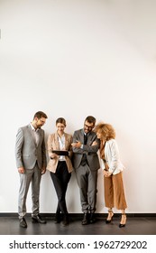 Multiethnic Business People Using Digital Tablet While Standing By The Wall In The Modern Office