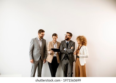 Multiethnic Business People Using Digital Tablet While Standing By The Wall In The Modern Office