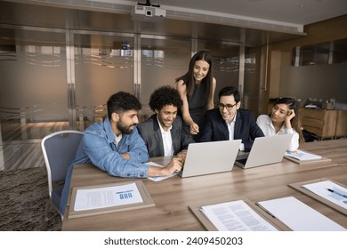 Multiethnic business team of happy colleagues using laptop for teamwork, online business communication, making group video call, watching virtual content, working on successful internet project