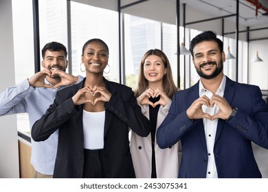 Multiethnic business team of happy coworkers in formal clothes making hand heart gesture, promoting support, charity, volunteering, looking at camera, smiling for office portrait - Powered by Shutterstock