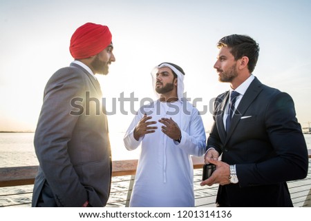 Multiethnic business team meeting outdoors - Three businessmen talking about business on a formal meeting