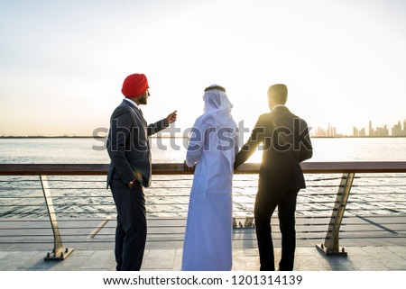 Multiethnic business team meeting outdoors - Three businessmen talking about business on a formal meeting