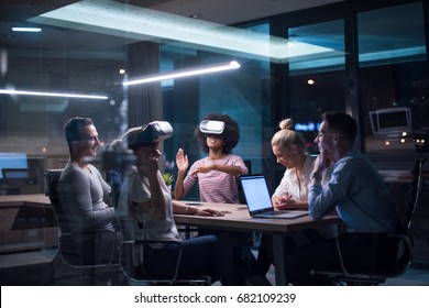 Multiethnic Business Team Using Virtual Reality Headset In Night Office Meeting  Developers Meeting With Virtual Reality Simulator Around Table In Creative Office.