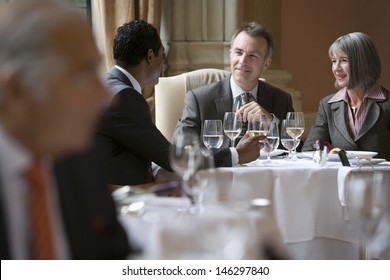 Multiethnic businesspeople sitting at restaurant table and talking
