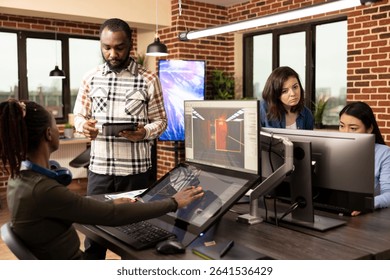 Multiethnic colleagues utilizing digital technology during their creative brainstorming session in modern workspace. Diverse team of employees working together in developing project designs in office.