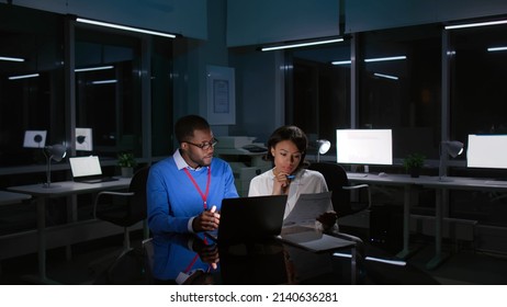 Multiethnic Colleagues Working Late On Laptop In Dark Office. 