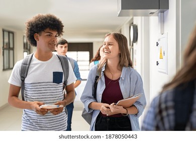 Multiethnic College Friends Walking In Campus And Talking While Having Break After Classes. University Students Having Fun After Lesson. High School Girl Smiling While Chatting With Her Black Guy.