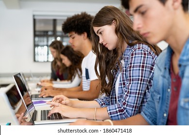 Multiethnic College Students Sitting In A Classroom Studying On Laptop During Class. Group Of Guys And Girls Using Laptop During Computer Lesson. Lifestyle And Mobile Communication Technologies.