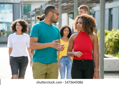 Multiethnic Couple Discussing Family Issues Outside. Young Latin Man And Black Woman In Casual Enjoying Walk, Talking, Discussing News. Walking Outside Concept