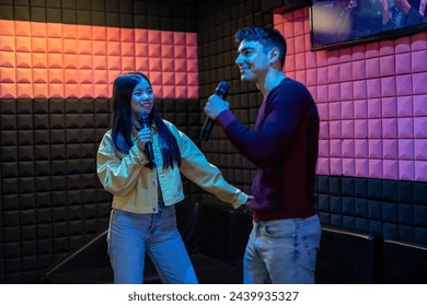 multiethnic couple singing and dancing in karaoke - first date after meeting on dating app - Powered by Shutterstock