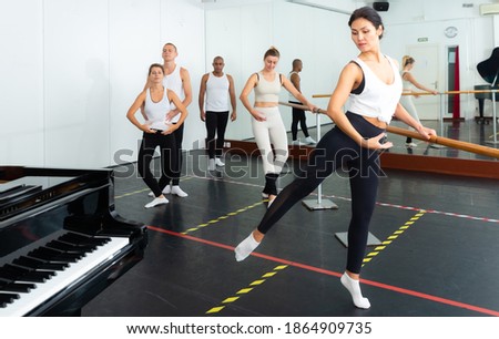 Multiethnic dancers practicing dance support in ballet studio