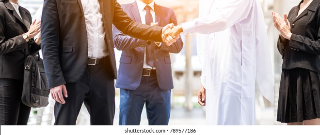 Multi-ethnic And Diverse Business People Shaking Hands. Business Deal Handshake With Arabic And European Ethnic Mans.