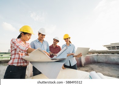 Multiethnic Diverse Group Of Engineers Or Business Partners At Construction Site, Working Together On Building's Blueprint, Architect Industry Or Teamwork Concept.